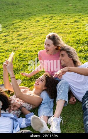 Amici felici che prendono un selfie su un prato Foto Stock