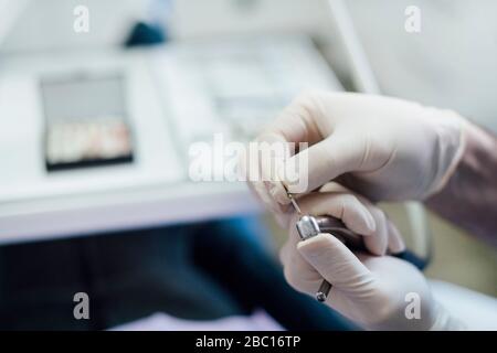 Primo piano del dentista che lavora su strumenti dentali Foto Stock