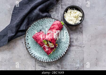 Involtini vegetariani di barbabietole riempiti con pomodori, cavolo rosso, mais, lattuga iceberg, cetrioli e formaggio cremoso Foto Stock