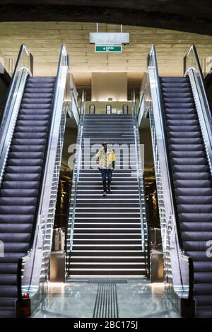 Uomo che cammina giù le scale nella stazione della metropolitana Foto Stock