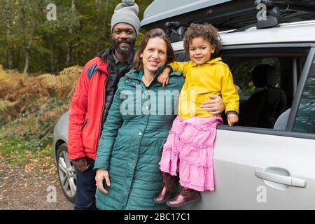 Ritratto felici i genitori e la figlia del bambino fuori dell'automobile Foto Stock