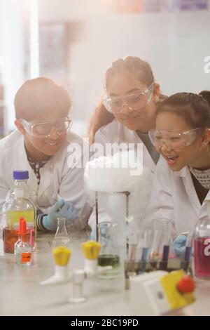 Sorpresi gli studenti che conducono esperimenti scientifici, osservano la reazione chimica in laboratorio in classe Foto Stock