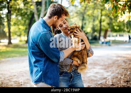 Giovane coppia felice con cane in un parco Foto Stock