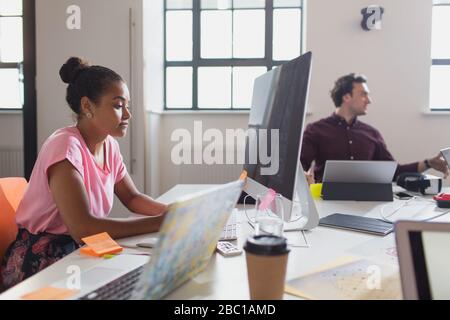 Designer femminile concentrato che lavora al computer in ufficio Foto Stock