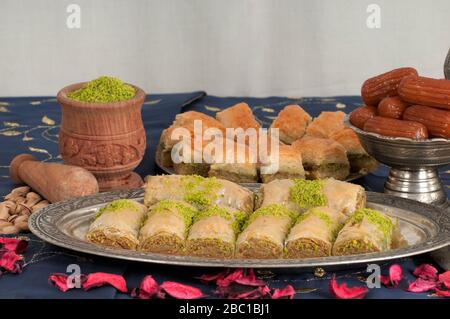 Un tavolo con dolci turchi tradizionali. Il baklava è fatto di pistacchio o noce. Il dessert di Tulumba è fatto da pasta e zucchero. Foto Stock