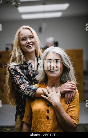 Ritratto di figlia adulta abbracciando madre felice all'aperto Foto Stock