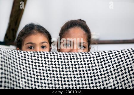 Ritratto di madre e bambina nascosto dietro poltrona Foto Stock