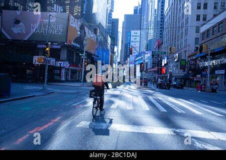 Food delivery worker guidare giù Broadway in times Square vuoto durante covid19 pandemic a NYC 03-30-2020 Foto Stock