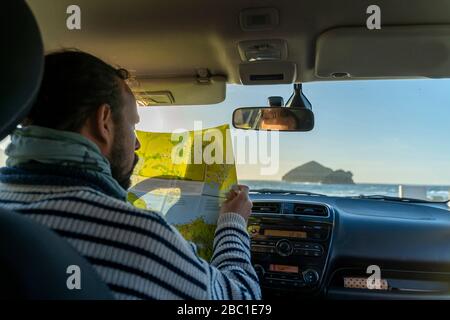 Uomo che guarda la mappa in auto, Sao Miguel Island, Azzorre, Portogallo Foto Stock
