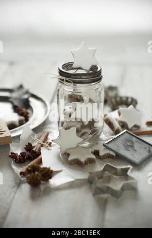 Biscotti a forma di stella, bastoncini di cannella, vecchia fotografia, coni di pino, taglierina per biscotti, anice stellato e vaso di vetro Foto Stock