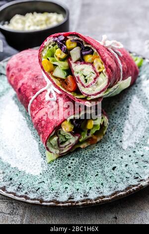 Involtini vegetariani di barbabietole riempiti con pomodori, cavolo rosso, mais, lattuga iceberg, cetrioli e formaggio cremoso Foto Stock