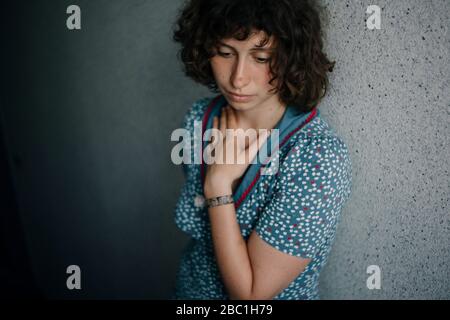 Ritratto di triste giovane donna appoggiata al muro Foto Stock