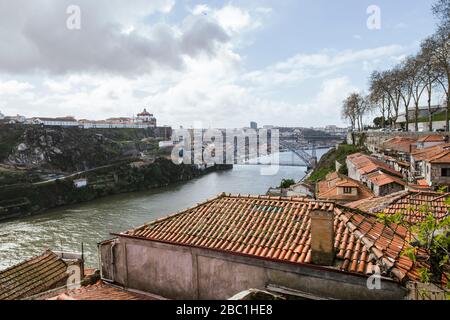 Portogallo, Porto, le case della città vecchia lungo il fiume Douro con il ponte Dom Luis i sullo sfondo Foto Stock