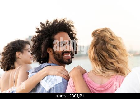 Ritratto di amici felici che abbracciano all'aperto Foto Stock