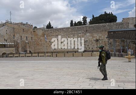 Città vecchia Gerusalemme, Israele. 02nd Apr, 2020. Una polizia di frontiera israeliana indossa una maschera protettiva e guanti, contro il coronavirus, al Muro Occidentale, il luogo più sacro del giudaismo, nella Città Vecchia di Gerusalemme, giovedì, aprile. 2, 2020. I casi di coronavirus sono saltati nelle città ultra-ortodosse israeliane, in mezzo alle crescenti preoccupazioni di un grande focolaio di COVID-19 nelle comunità religiose. Foto di Debbie Hill/UPI Credit: UPI/Alamy Live News Foto Stock