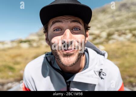 Ritratto di giovane sorridente che guarda la macchina fotografica, seduto in barca a remi Foto Stock