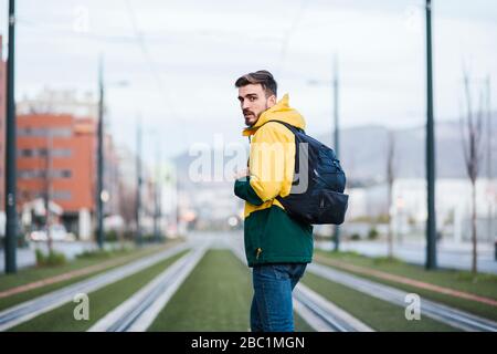 Ritratto di uomo con zaino in città su tram tracce Foto Stock