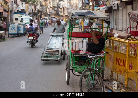 Autista che dorme sul suo risciò in bicicletta a Old Delhi, India Foto Stock