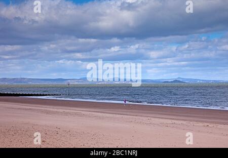 Portobello, Edimburgo, Scozia, Regno Unito. 2 aprile 2020. Fotografo a metà pomeriggio su permesso periodo stralcio indossare una maschera testimoni la spiaggia quasi deserta e panche vacanti a causa degli effetti del pubblico aderire al soggiorno a casa avvertimenti e il messaggio del governo circa i pericoli del Coronavirus Covid-19. Foto Stock