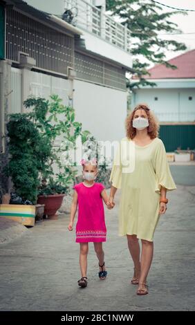 Donna e figlia che indossano maschera facciale monouso per evitare infezioni virali. Protezione da coronavirus Foto Stock