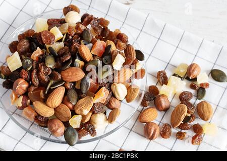 Mix di frutta secca e noci diverse in vetro piatto primo piano. Super alimenti, sano concetto di mangiare. Foto Stock