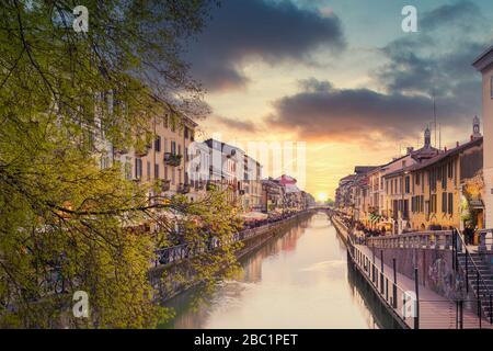 Il canale Naviglio Grande al tramonto, ai lati del canale, i tipici bar, ristoranti e negozi della 'Milanese Movida', Lombardia Italia. Foto Stock