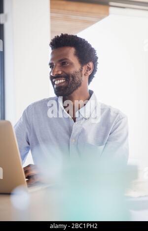 Sorridente imprenditore lavora al computer portatile Foto Stock
