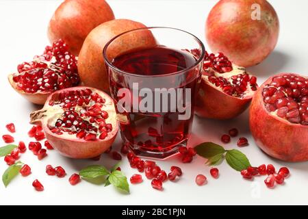 Melograno, succo e semi su sfondo bianco, primo piano Foto Stock