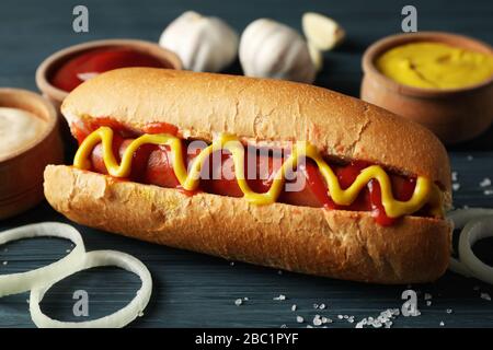 Gustoso cane caldo e ingredienti su sfondo di legno Foto Stock