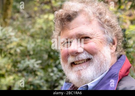 Amichevole felice bearded maschio anziano con un twinkle nel suo occhio, un uomo caldo, gentile sicuro anziano fuori Foto Stock