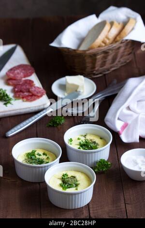 Colazione con omelette, salsiccia, pane e burro su sfondo scuro. Foto Stock