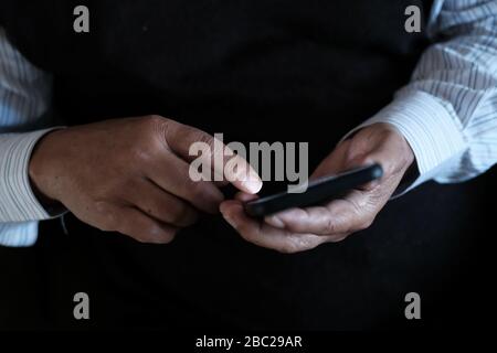 Primo piano di persone anziane utilizzare smartphone indoor Foto Stock