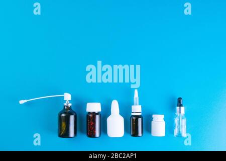 Diversi flaconcini con e spray con medicinali sono rivestiti in fila retta. Viste dall'alto con spazio libero Foto Stock