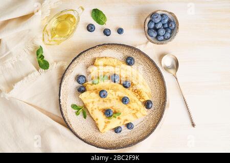 Due pancake con mirtilli e menta su piastra, vista dall'alto Foto Stock