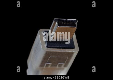 Connettore maschio USB mini B isolato su sfondo nero. Connettore dati cammera digitale a 5 pin comune. Foto Stock