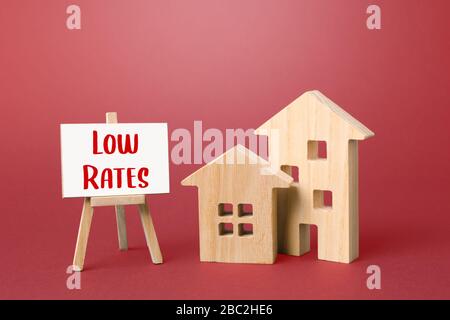 Figurine di case e un cavalletto a basso prezzo. Grandi promozioni e sconti sulle vendite a domicilio. Bassa domanda di immobili e alloggi, recessione economica e. Foto Stock