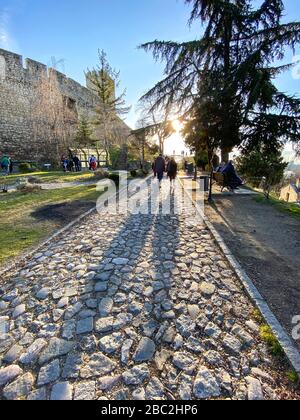 Una coppia di sagome cammina lungo un sentiero acciottolato lungo il castello di Belgrado, Serbia. Foto Stock