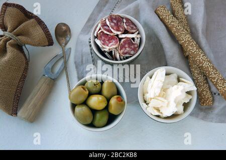 delizioso piatto di antipasti con diversi prodotti a base di carne e formaggio. formaggio, olive e prosciutto per una colazione semplice. tovagliolo di lino e piccolo Foto Stock