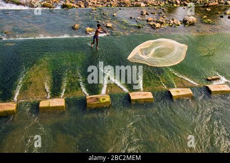 pescatore lancia un fishingnet per catturare pesce candid cattura Foto Stock
