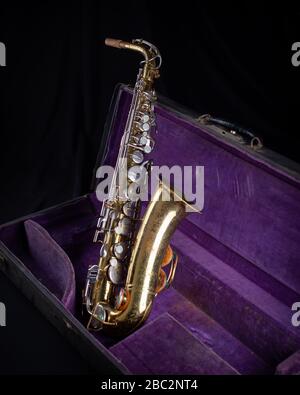 Buescher Alto Sax, laccato oro in Deep Purple Velvet-foderato Hard Case lato 1 su sfondo nero Foto Stock