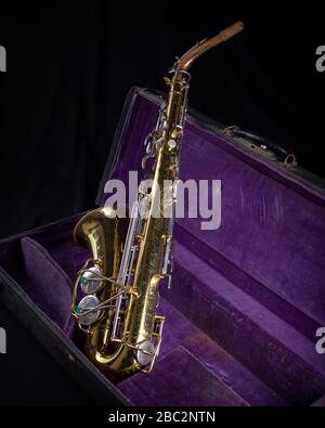 Buescher Alto Sax, laccato oro in Deep Purple Velvet-foderato Hard Case back 1 su sfondo nero Foto Stock