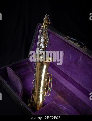 Buescher Alto Sax, laccato oro in Deep Purple Velvet-foderato Hard Case anteriore su sfondo nero Foto Stock