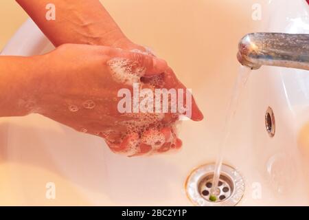 Lavando le mani con sapone, mani di donna Foto Stock