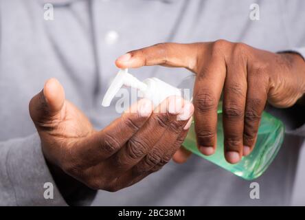 Protezione antivirus Corona. Mani con dispenser di gel igienizzante per le mani. Concetto di salute per uccidere germi, batteri e virus. Foto Stock