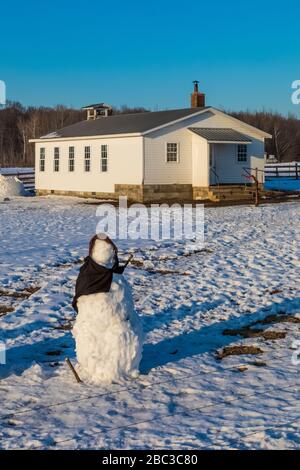 Pupazzo di neve, davvero una donna di neve, senza caratteristiche facciali, fatto da bambini Amish presso la loro scuola di una camera nel centro del Michigan, Stati Uniti [Nessuna proprietà rele Foto Stock