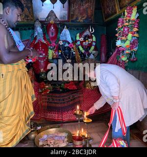 Donna occidentale illuminazione lampada in un tempio indù, Odisha, India Foto Stock