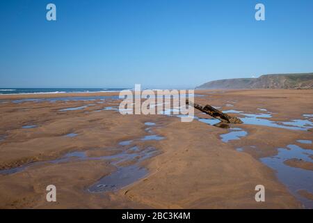 Pericolosi pezzi di relitto che si attaccano dalla spiaggia saranno nascosti quando la marea è dentro. Bella spiaggia di Sandymouth, Bude Bay, Cornwall Foto Stock