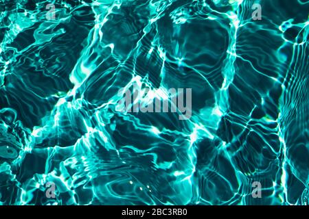 Closeup di acqua ruvida superficie texture con schizzi e bolle in verde scuro colore smeraldo. Trendy fresco astratto natura sfondo. Foto Stock