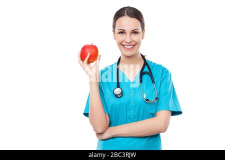 Medico femminile che tiene una mela Foto Stock