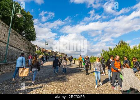 La gente cammina sulla famosa strada pedonale turistica (Via Sant'Alessandro) vicino a porta San Giacomo nella città alta di Bergamo Foto Stock